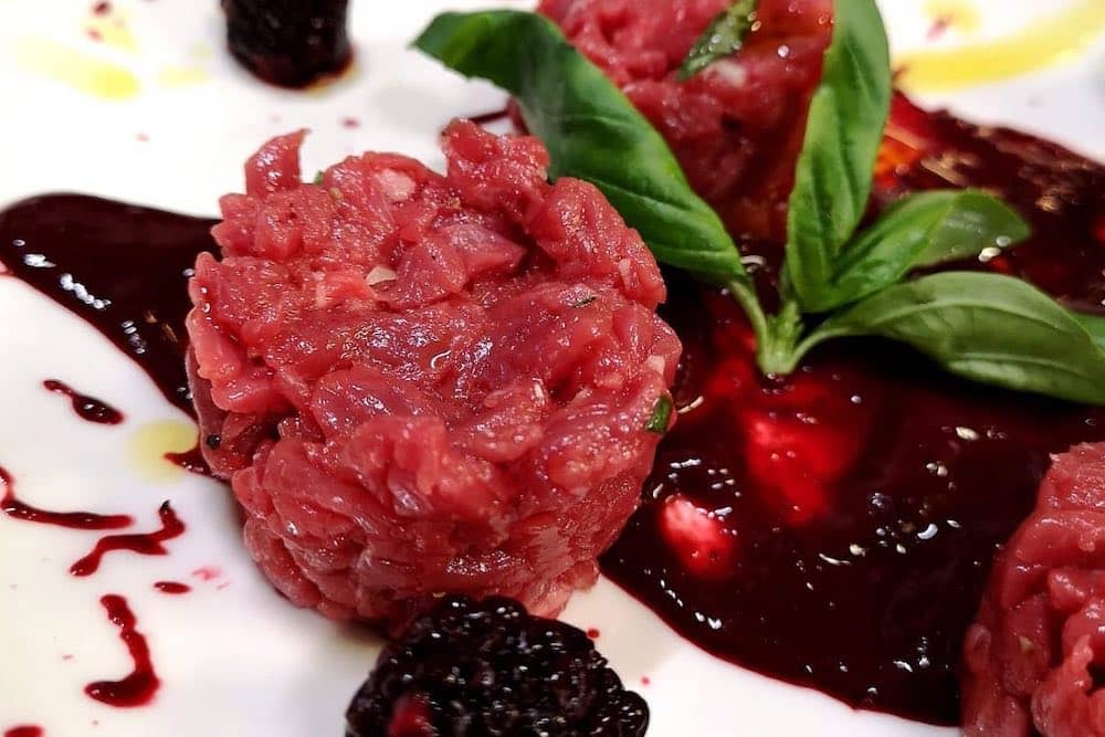 battuta al coltello con coulis di frutti di bosco